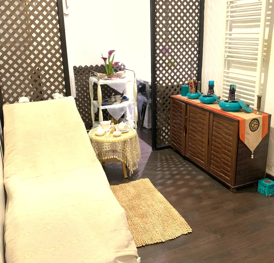 Cabine de massage avec claustra en bois et pots turquoise
