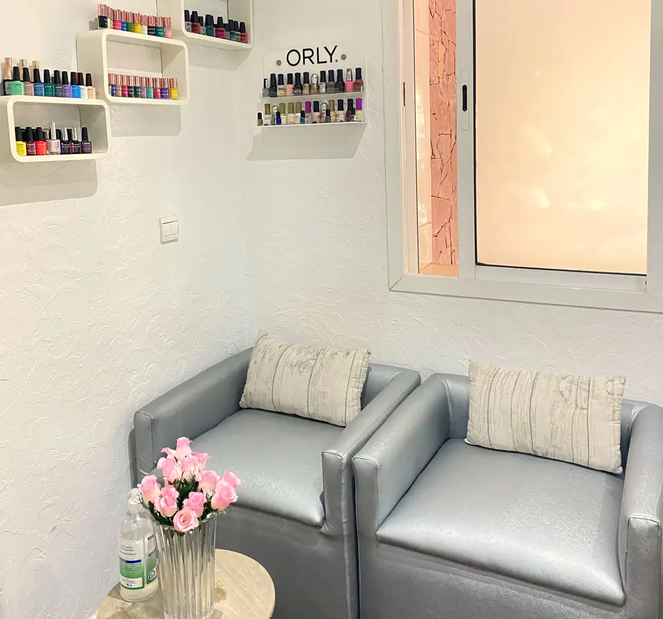 Coin manucure : fauteuils gris et présentoir de vernis